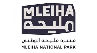 The image shows a logo with the name "Mleiha National Park  " written in orange letters.The background is white