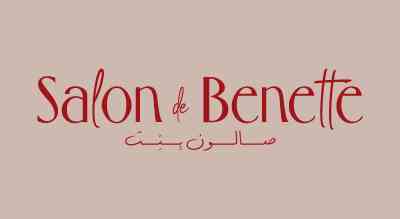 The image shows theSalon DeBenette logo. The text is in red, , and the background is pink